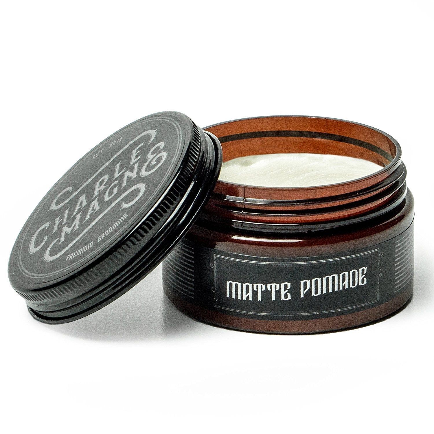 Pot ouvert en verre brun avec couvercle noir, rempli de pommade blanche.