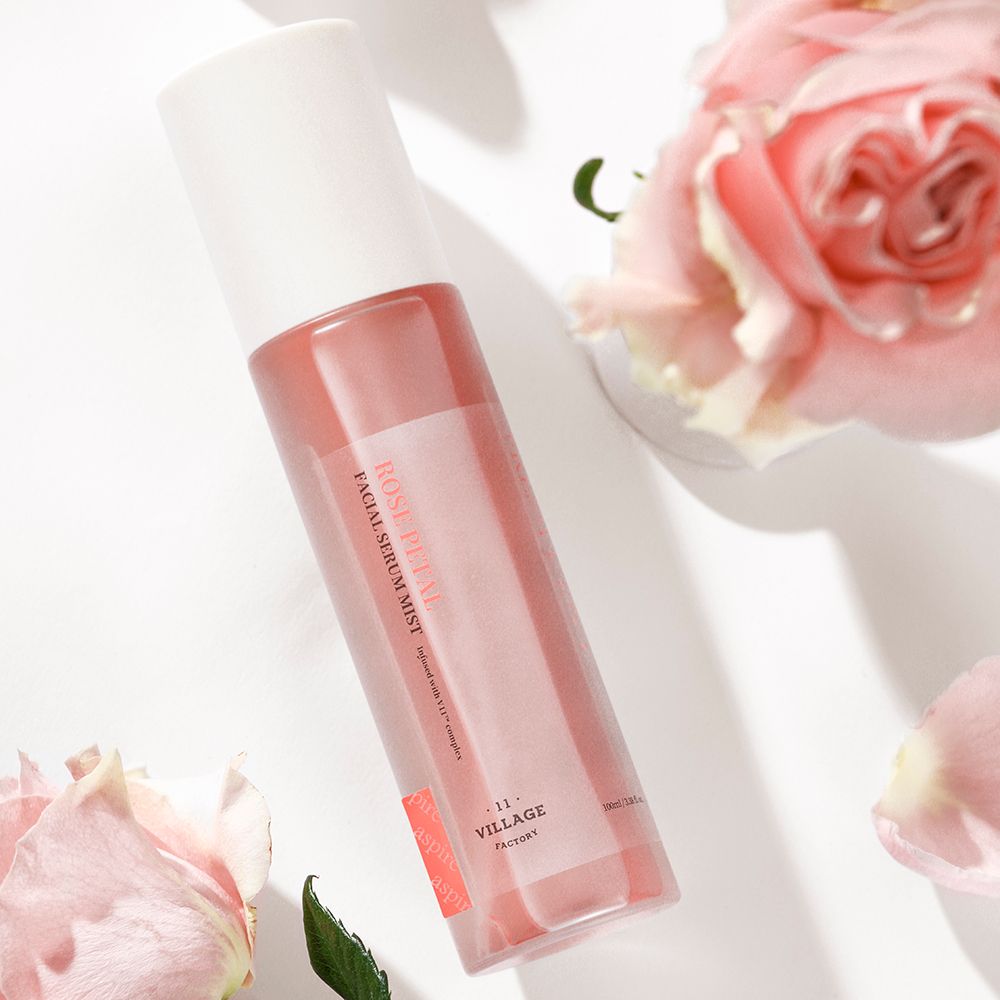 Gezichtsserumspray met rozen. Opschrift: ROSE PETAL FACIAL SERUM MIST. Schuin van bovenaf gezien.
