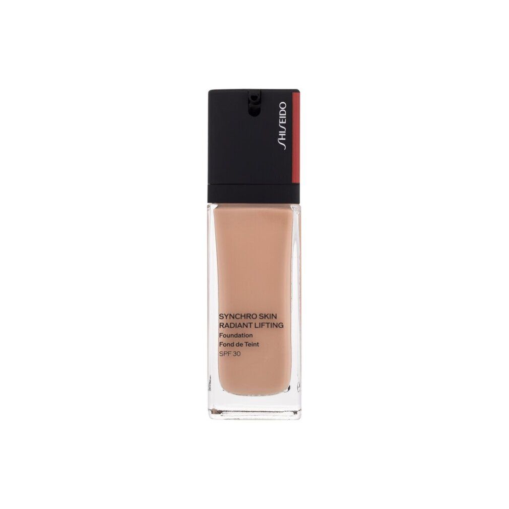 Flacon de fond de teint beige. Bouchon noir avec bande rouge et logo SHISEIDO. Nom du produit et désignation sur l'étiquette.