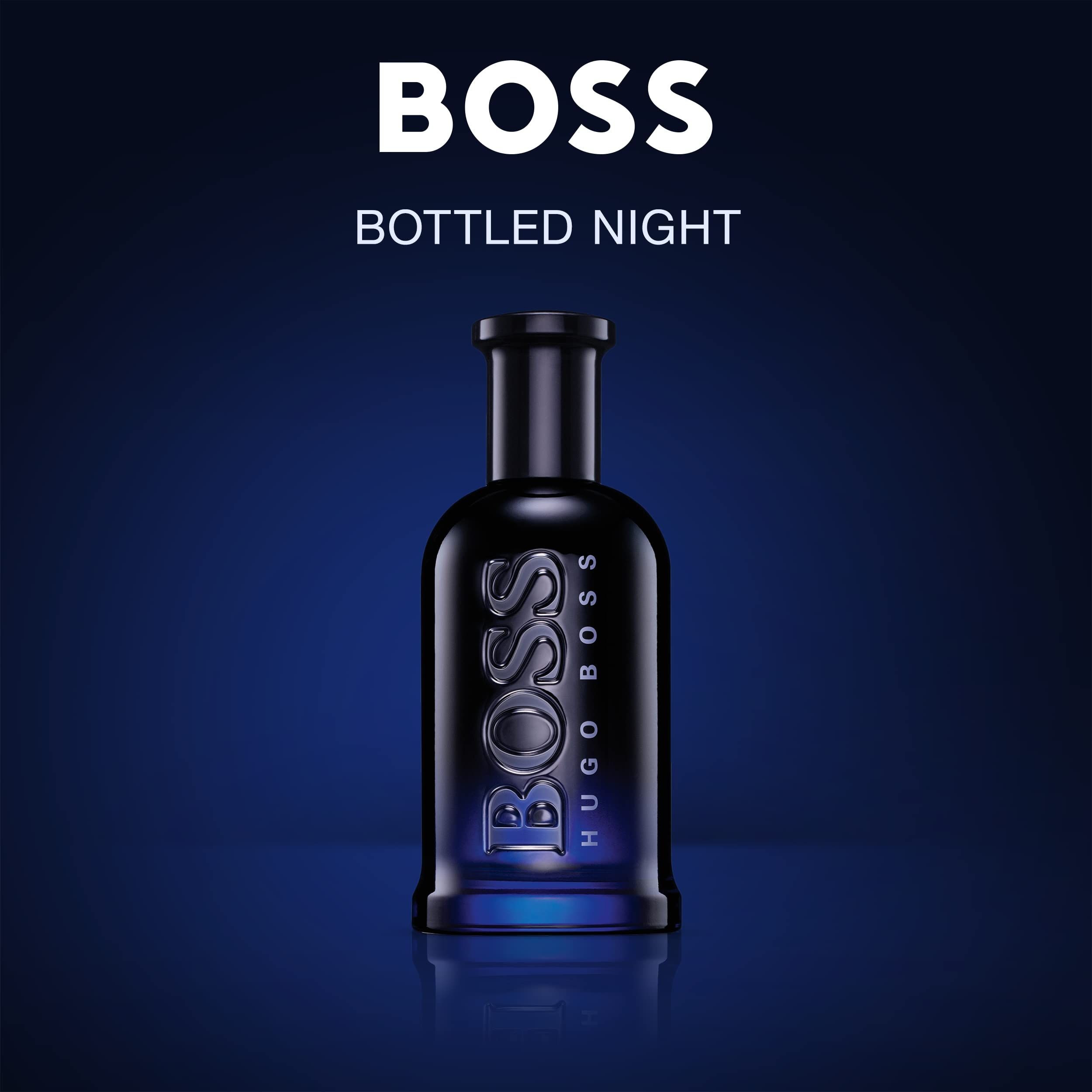 Donkerblauwe glazen fles met zilveren BOSS HUGO BOSS opschrift op blauwe achtergrond.