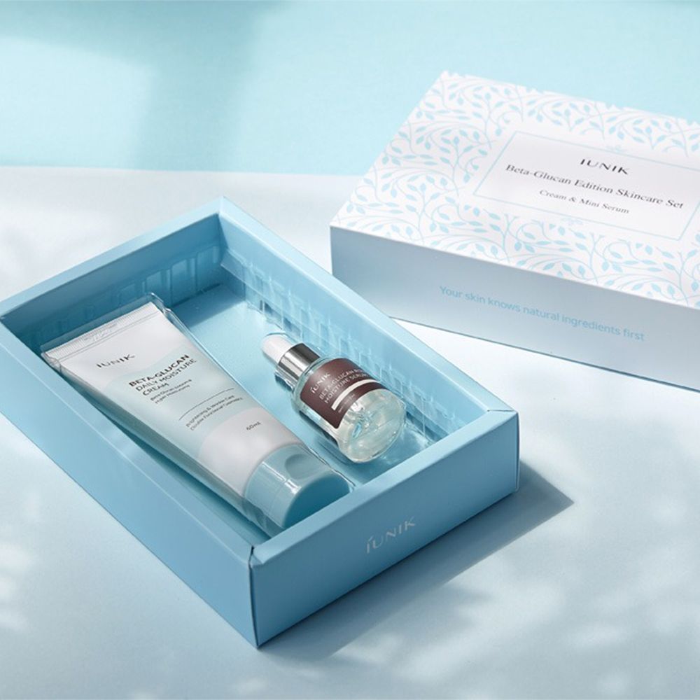 Set de soins iUNIK Beta-Glucan : Crème et sérum dans une boîte bleue, à côté de l'emballage du produit.