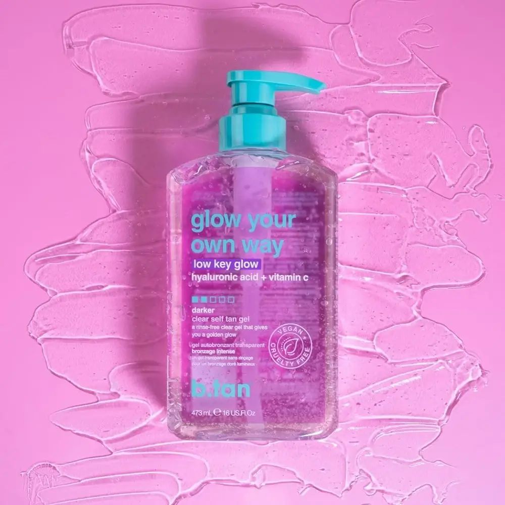 Flacon transparent avec pompe turquoise sur fond rose avec gel. Étiquette avec texte : glow your own way, low key glow.