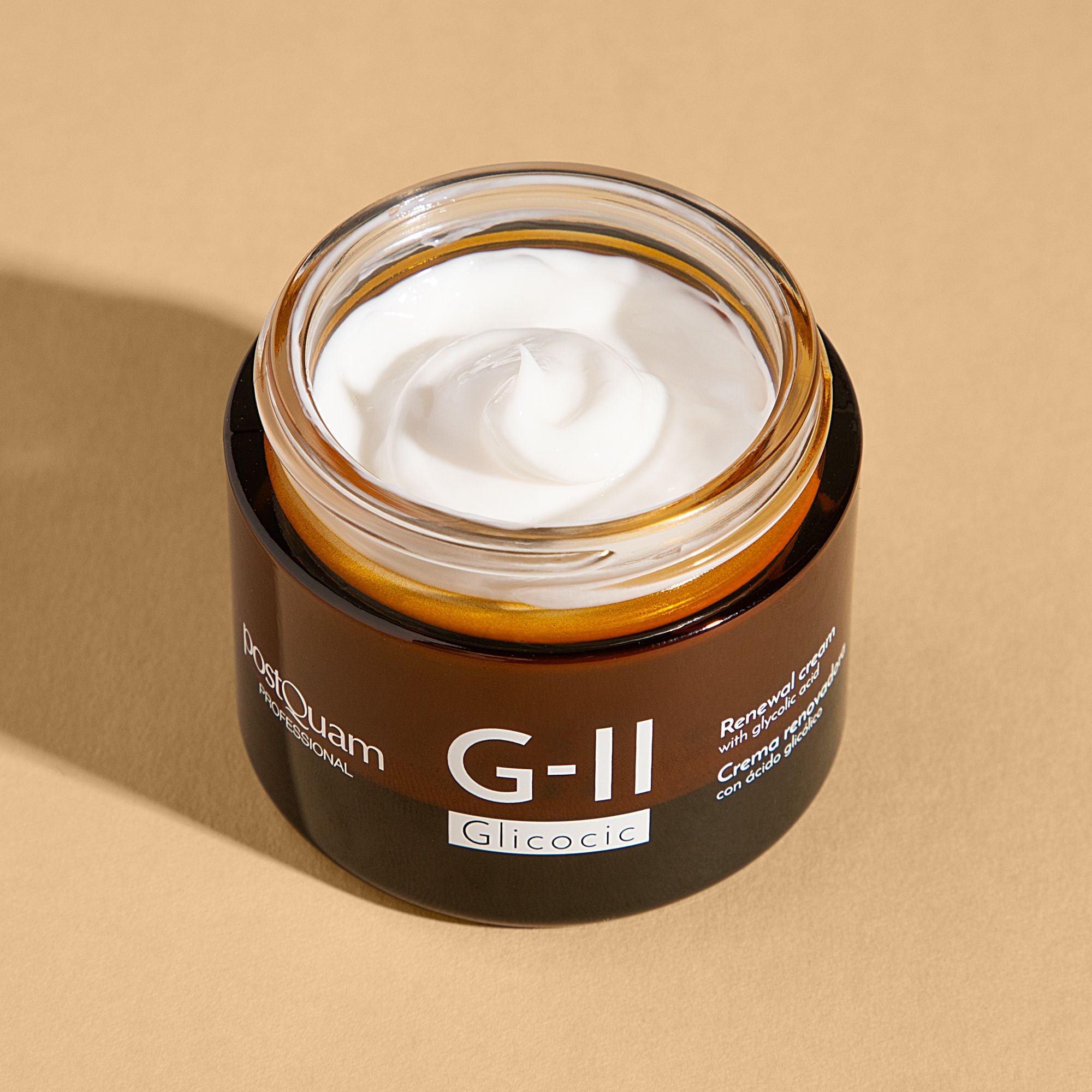 Crème ouverte dans un pot en verre brun. Inscription G-II Glycolic. Texte : Renewal cream with glycolic acid. Crème visible.