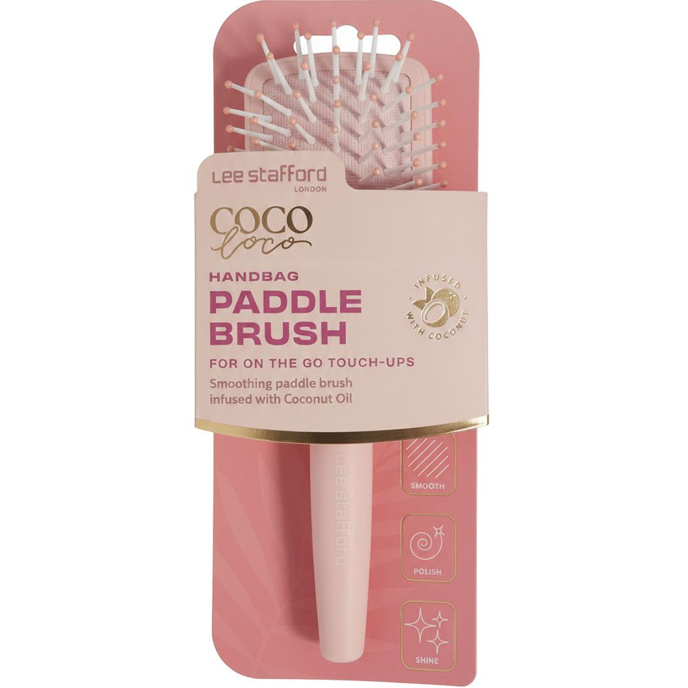 Une brosse à cheveux rose pâle dans son emballage, nom du produit 'Coco Loco Handbag Paddle Brush'.