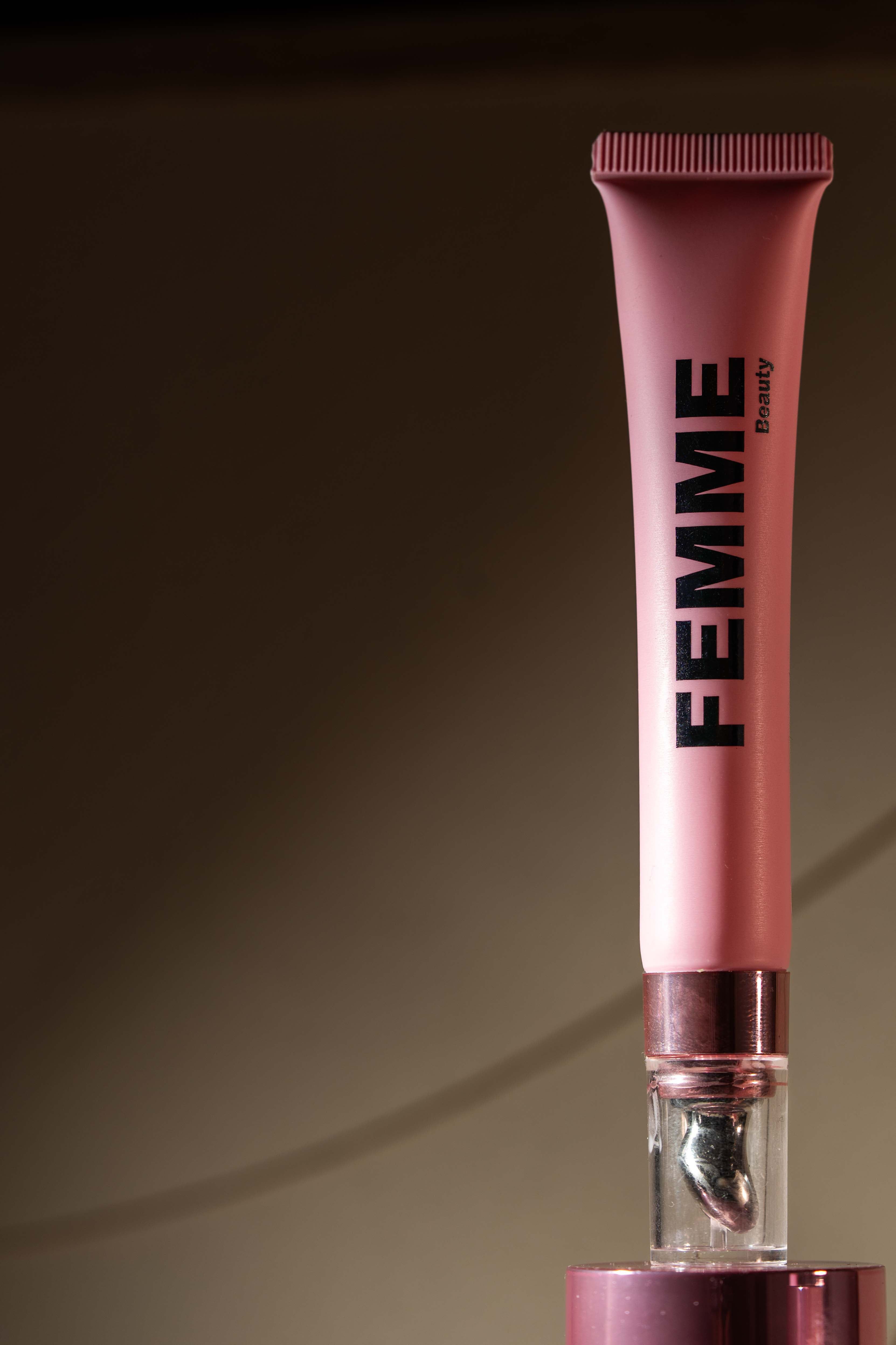 Crème contour des yeux FEMME Beauty dans un tube rose avec applicateur.