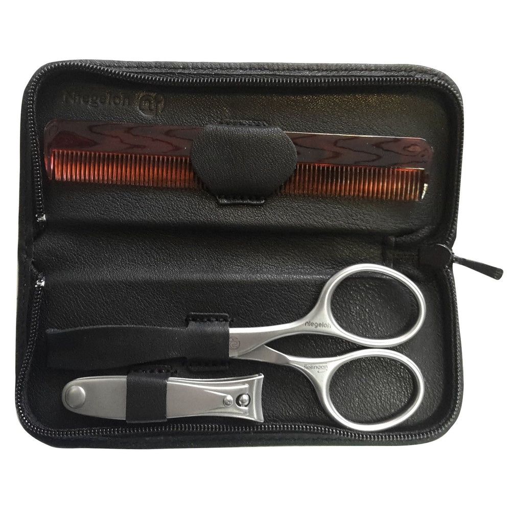 Zwarte etui met kam, schaar en nagelknipper. Binnenvoering. Ritssluiting. Niegeloh-logo.
