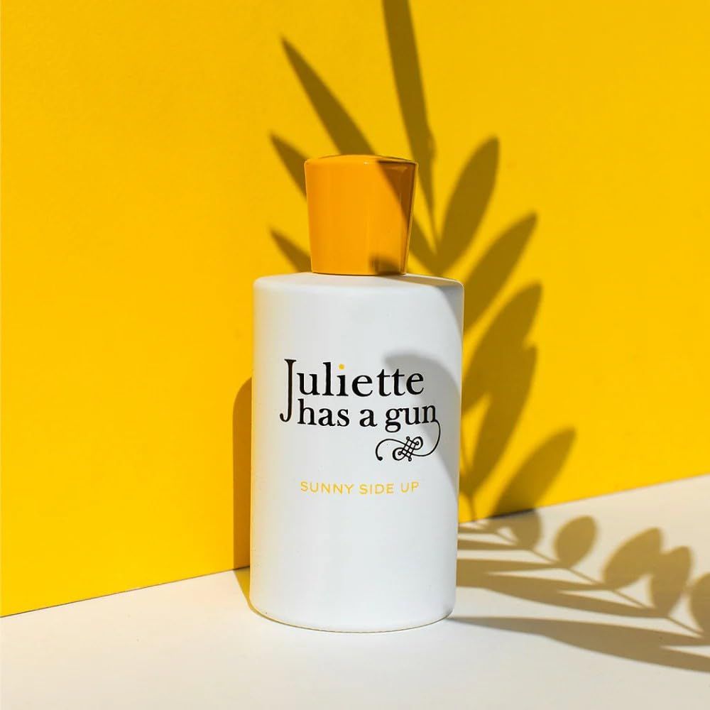 Flacon blanc à bouchon jaune sur fond jaune. Texte noir: Juliette has a gun, Sunny Side Up.