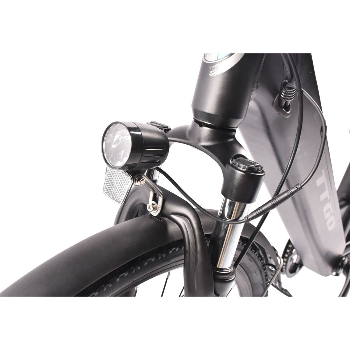 Gros plan du phare et du garde-boue d'un vélo électrique noir. Logo TTGO visible.