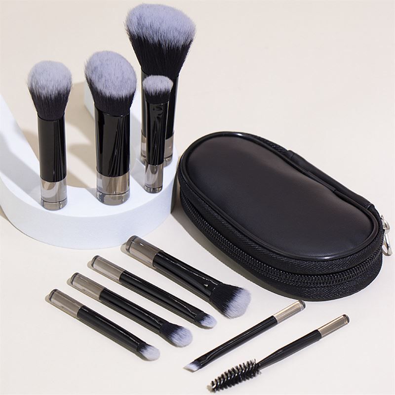 Zwarte etui met rits en make-up kwastenset. Penselen met zwarte handvatten en zilveren uiteinden.
