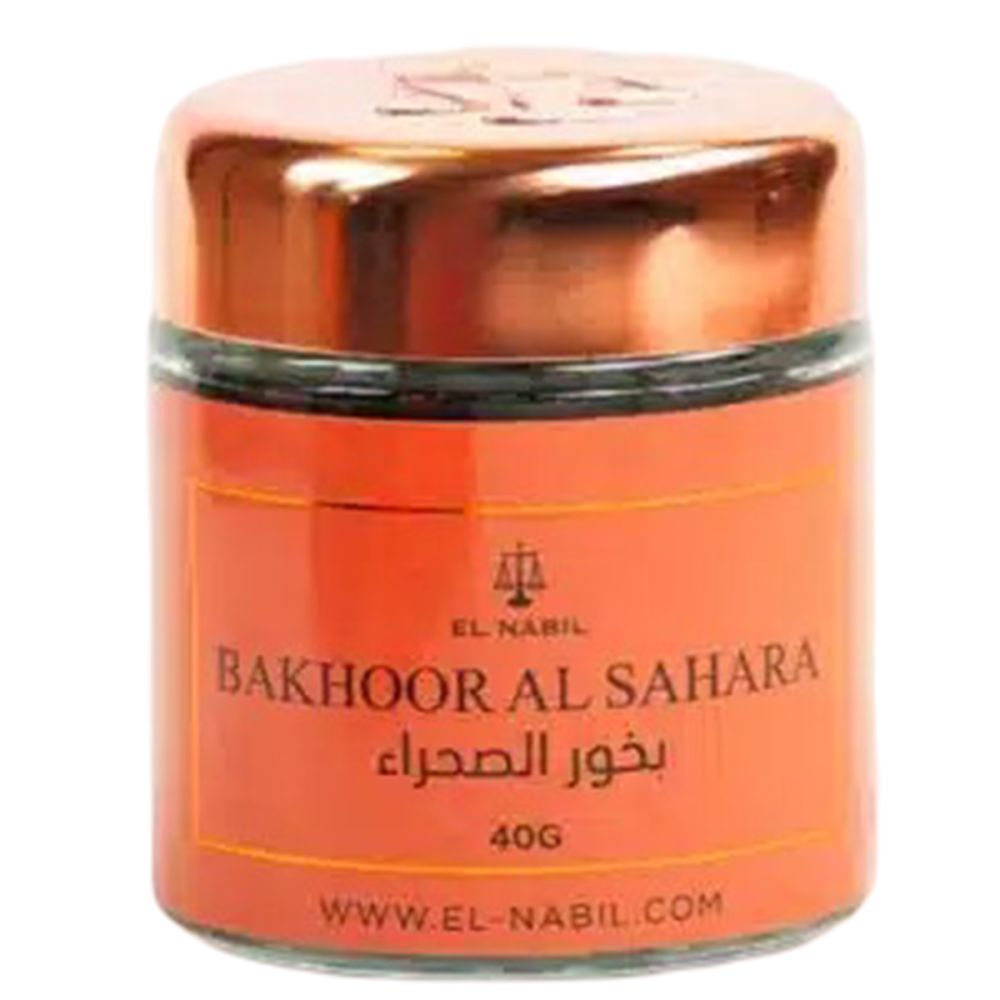 Pot en verre rond avec couvercle cuivré. Inscription : Bakhoor Al Sahara, 40g. Étiquette orange avec logo et site web.