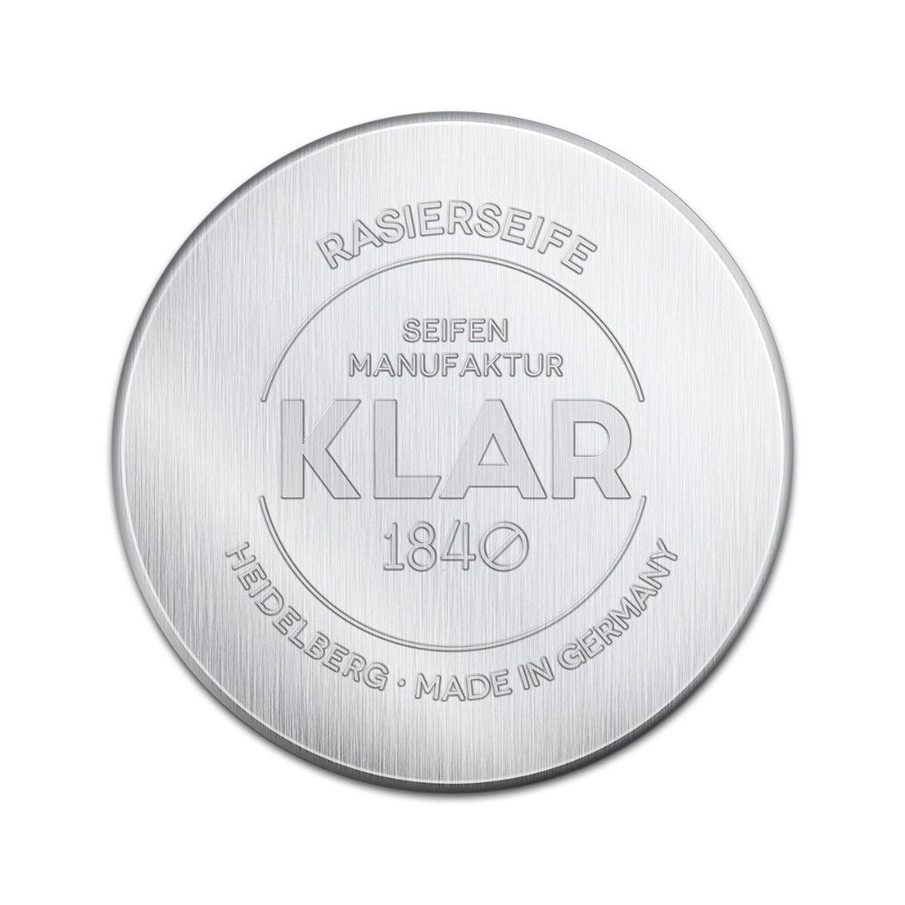 Ronde, zilverkleurige zeep met reliëf: RASIERSEIFE, KLAR, 1840, SEIFEN MANUFAKTUR, HEIDELBERG, MADE IN GERMANY.