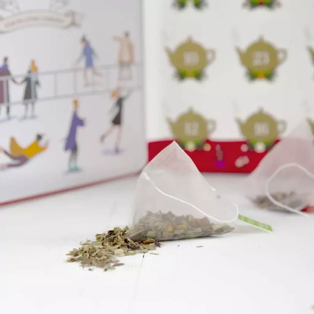 Sachet de thé avec thé en vrac à côté. Calendrier de l'Avent en arrière-plan avec motifs de théières et chiffres.