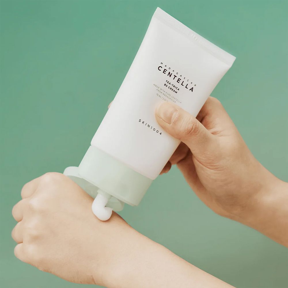 Main appliquant de la crème du tube SKIN1004 Centella Tea-Trica B5 Cream.