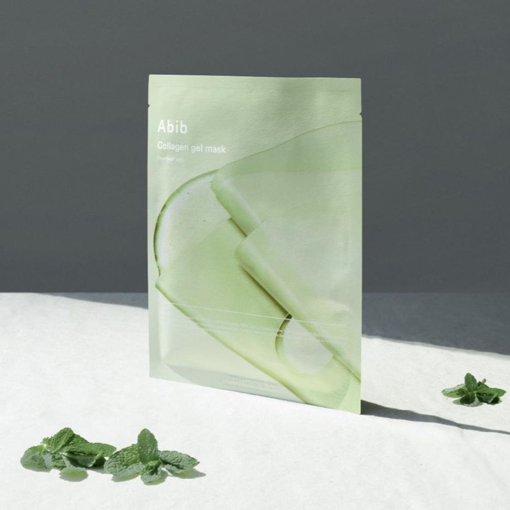 Groene verpakking met product. Opschrift: Abib Collagen Gel Mask Heartleaf Jelly. Masker en bladeren ernaast.
