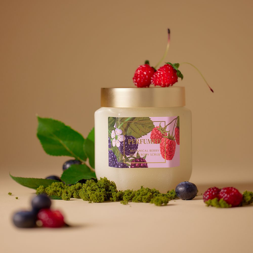 Glazen pot met gouden deksel, omringd door bladeren en bessen. Etiket met bessen- en bloemenillustraties. Opschrift: PERFUMED.
