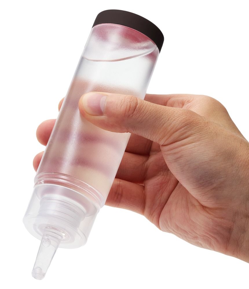 Transparante fles met bruine dop, vastgehouden door een hand. De inhoud is zichtbaar.