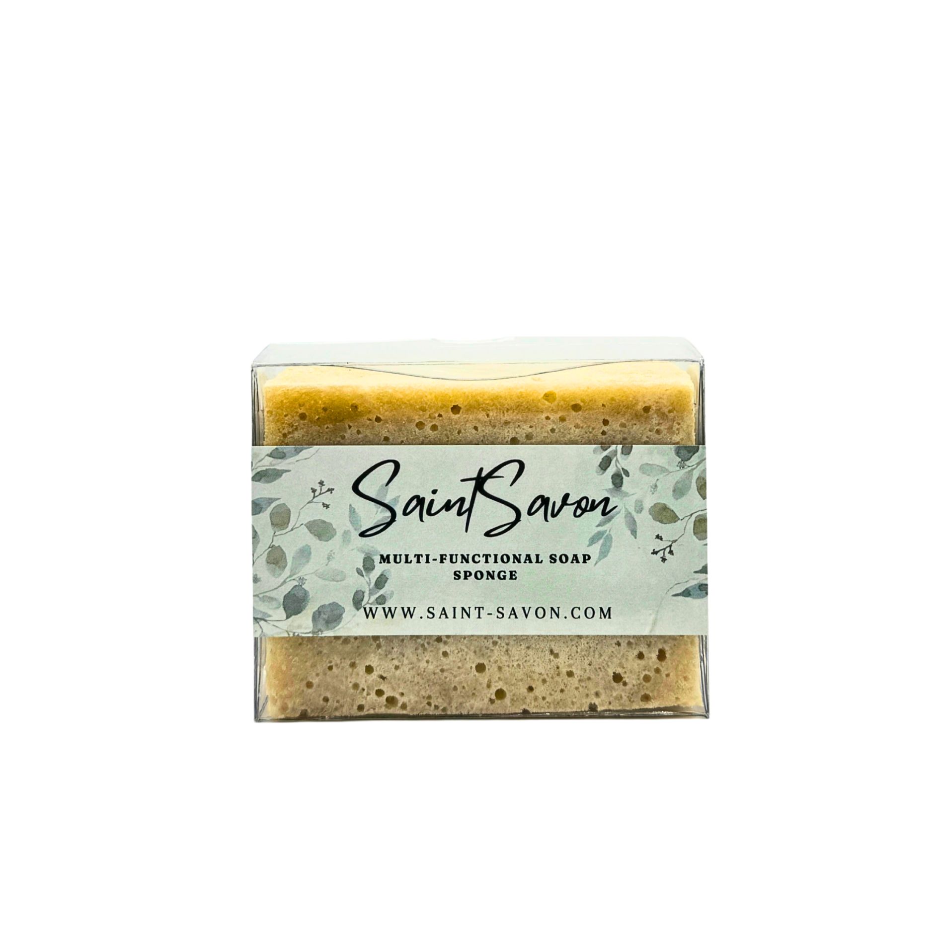 Éponge rectangulaire dans un emballage transparent. L'étiquette indique "Saint Savon", "Multi-Functional Soap Sponge" et le site web.