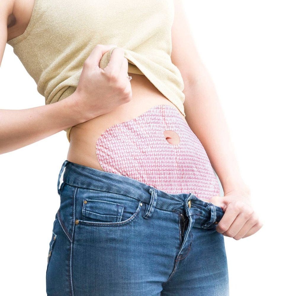 Personne portant un patch amincissant sur le ventre. Le patch est rose et percé d'un trou.
