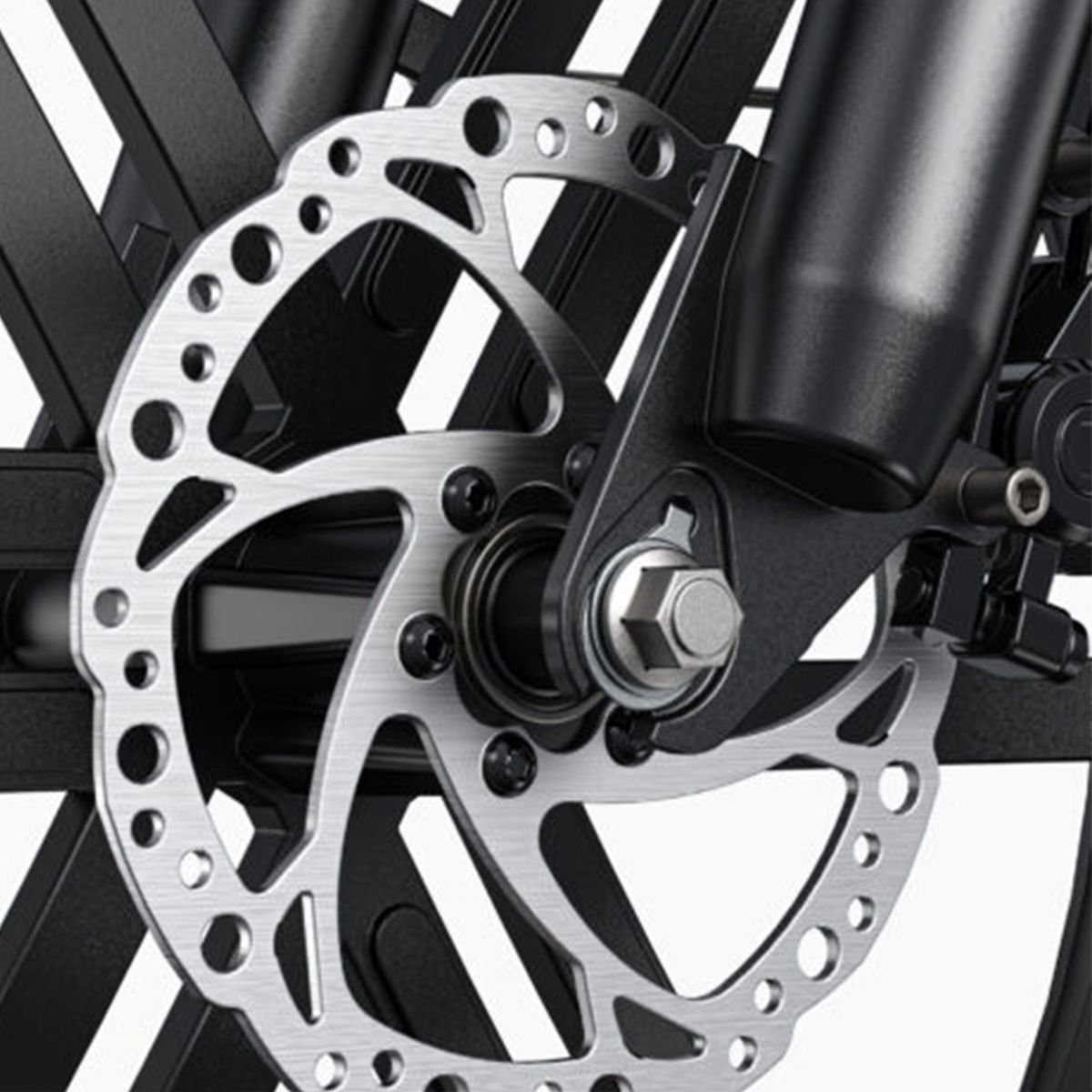 Gros plan sur le frein avant d'un vélo. Disque de frein argenté percé, fourche noire.