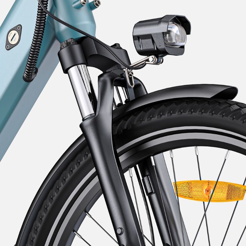 Close-up van de voorvork van een e-bike met koplamp en spatbord. De koplamp is zwart.