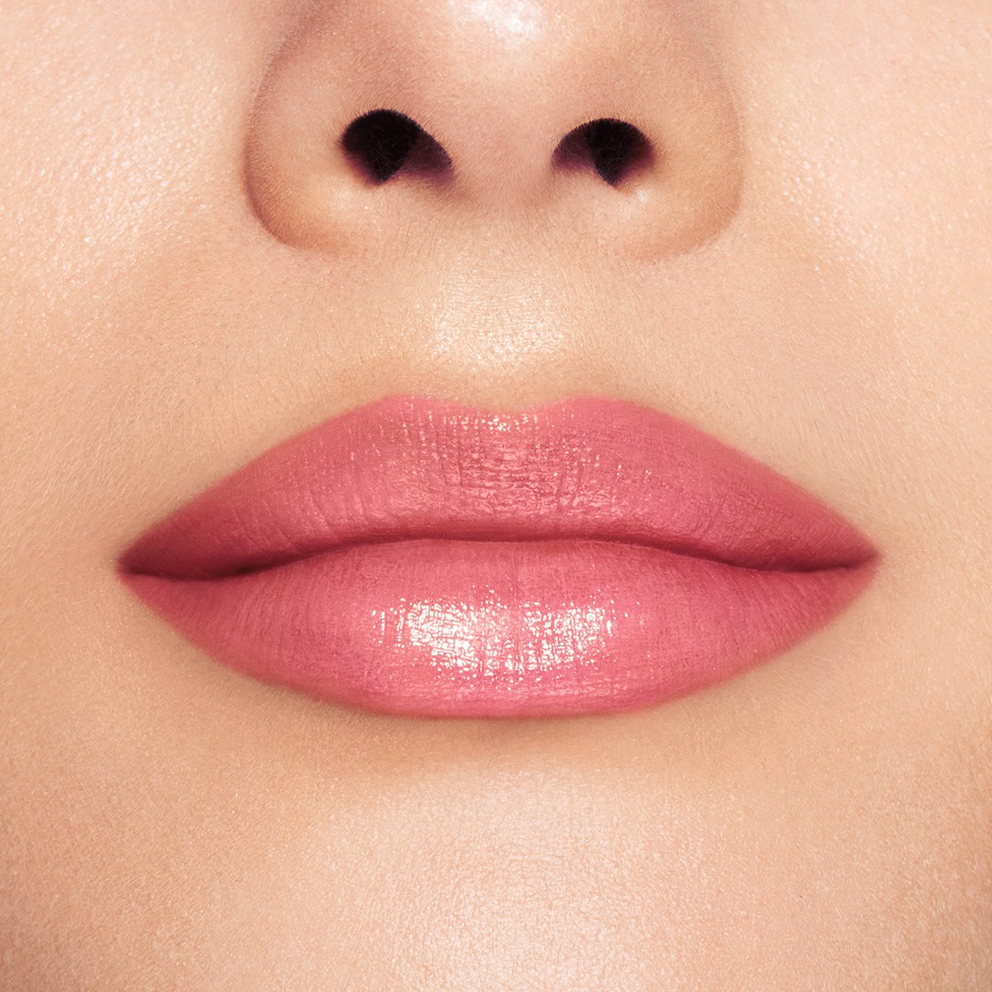 Close-up van lippen met roze lippenbalsem. Glanzende finish.