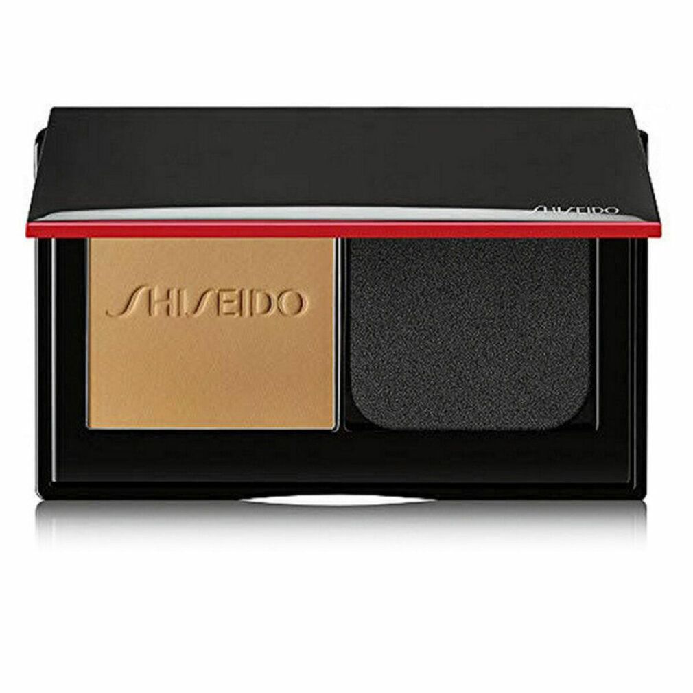 Poudre compacte avec poudre et éponge. Cadre noir, accent rouge. Logo Shiseido.