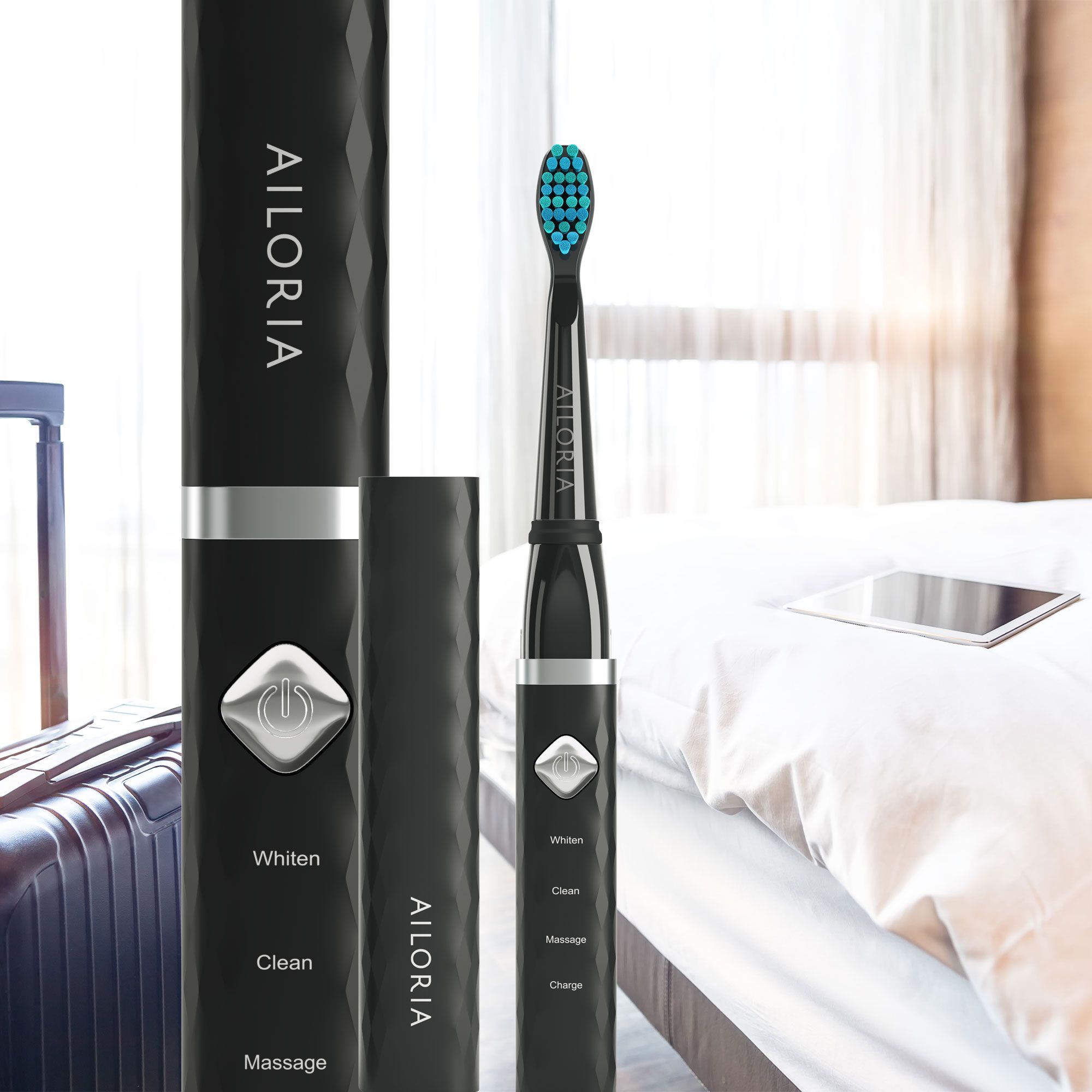 Brosse à dents noire avec étui et accessoires sur un lit. Logo AILORIA. Whiten, Clean, Massage, Charge.