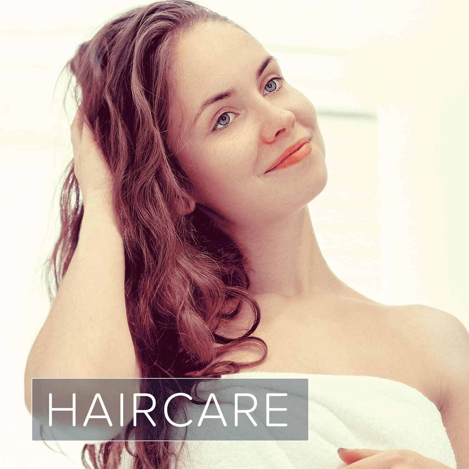 Vrouw met lang bruin haar. Ze raakt haar haar aan. Tekst: HAIRCARE.