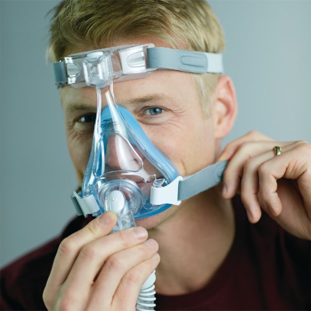 Homme avec masque CPAP Philips Amara SE Gel Full : mise en place du masque buccal et nasal.