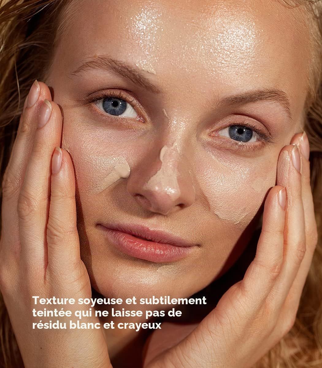 Femme appliquant une crème hydratante teintée, texture soyeuse et légère.