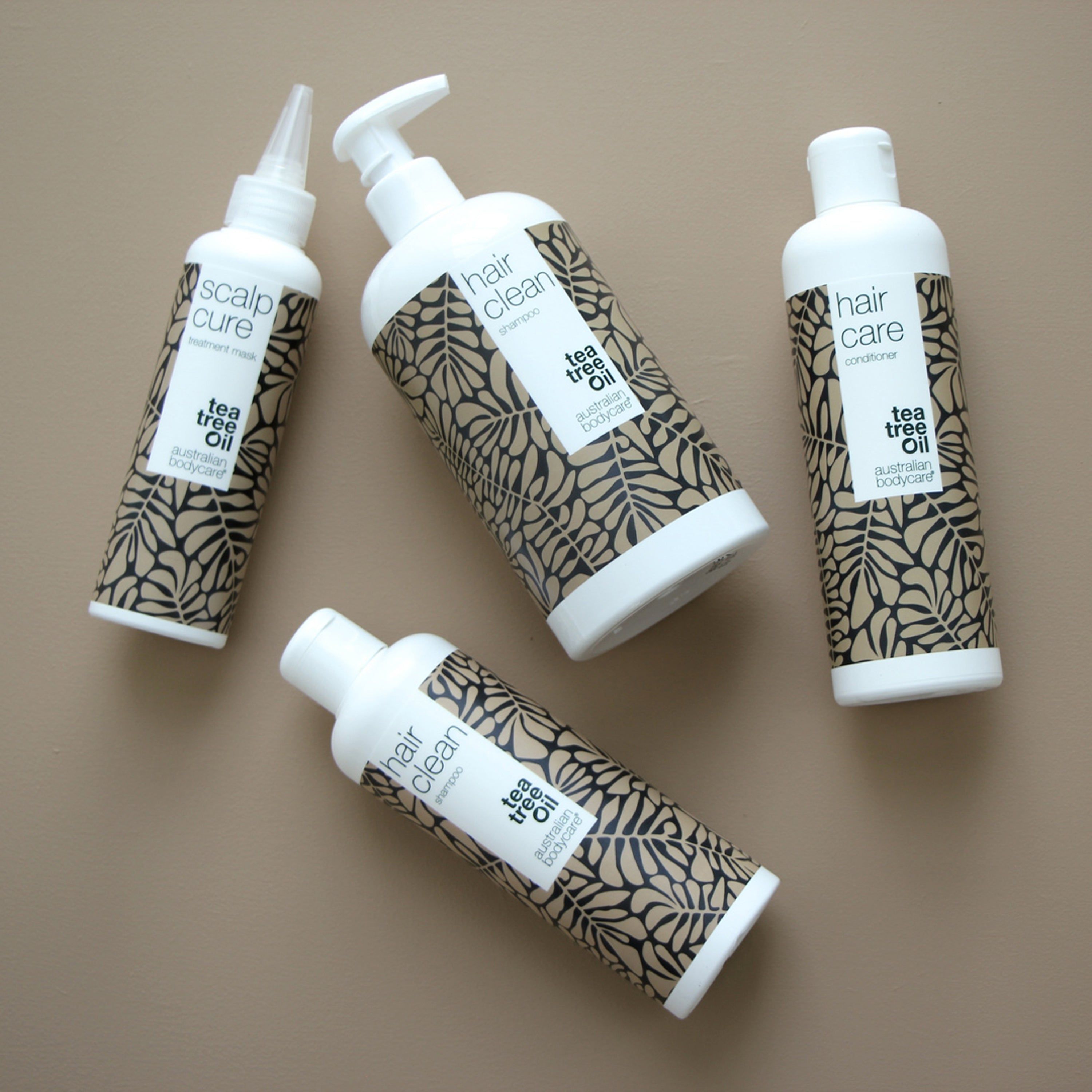 Verschillende flessen en tubes. Opschrift: hair clean shampoo, tea tree Oil, australian bodycare.