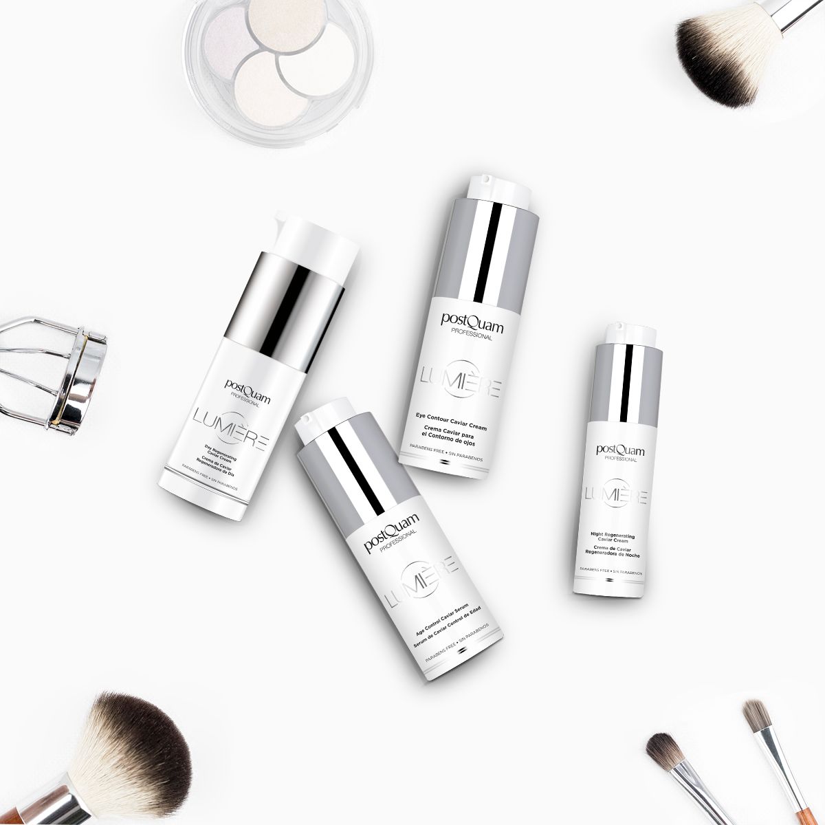 Plusieurs flacons de crème, pinceaux de maquillage, recourbe-cils et palette d'ombres à paupières sur fond blanc. Inscription : PostQuam Lumière.