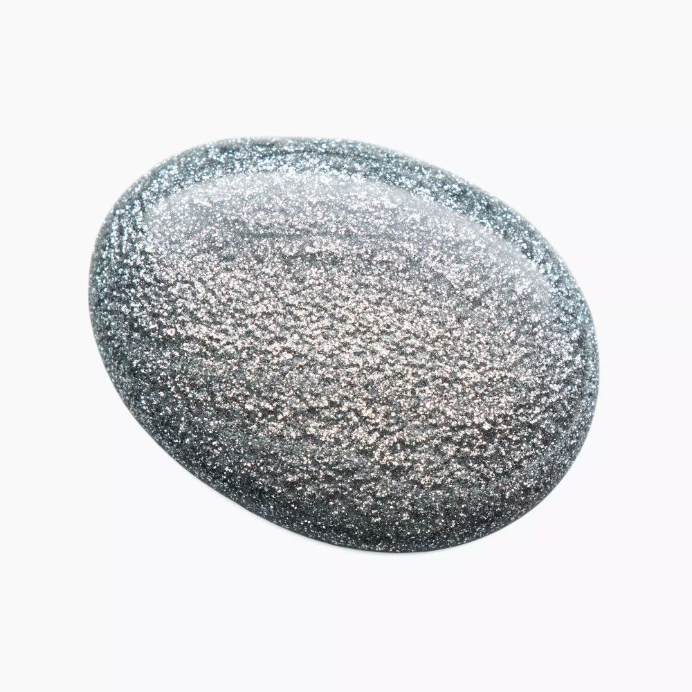 Goutte de vernis à ongles argenté sur fond blanc. Forme ovale.