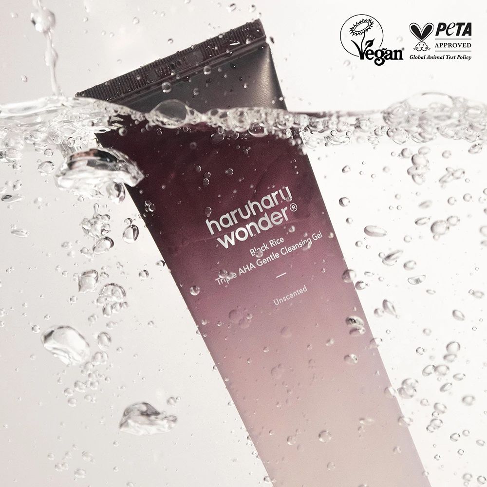 Tube in water. Opschrift: Haruharu Wonder Black Rice Triple AHA Gentle Cleansing Gel. Vegan- en PETA-keurmerk. Waterbellen.