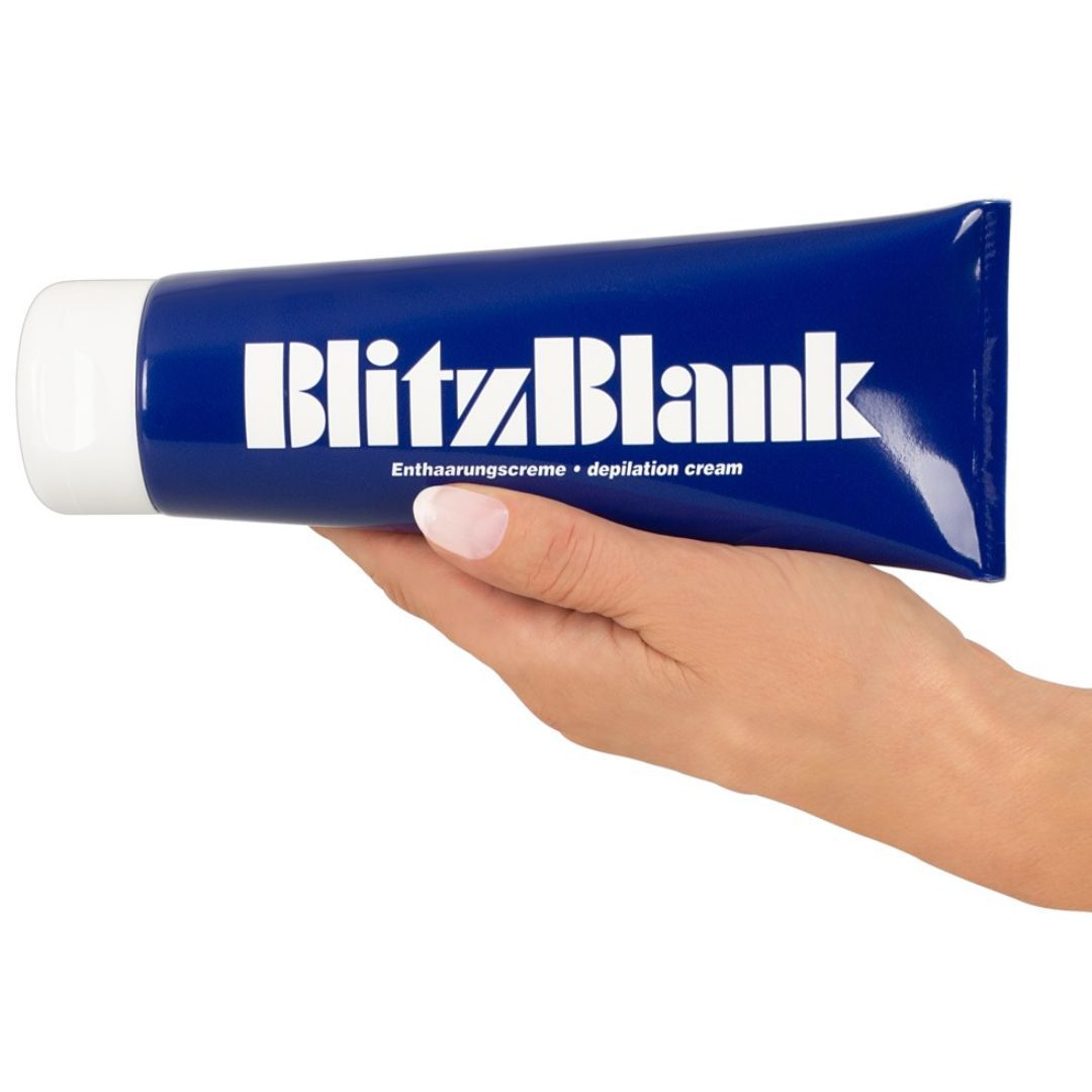 Hand die een blauwe tube BlitzBlank ontharingscrème met witte opdruk vasthoudt.