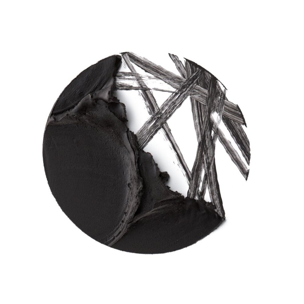 Gros plan circulaire de gel eyeliner noir. Quelques traits sont visibles sur fond blanc.