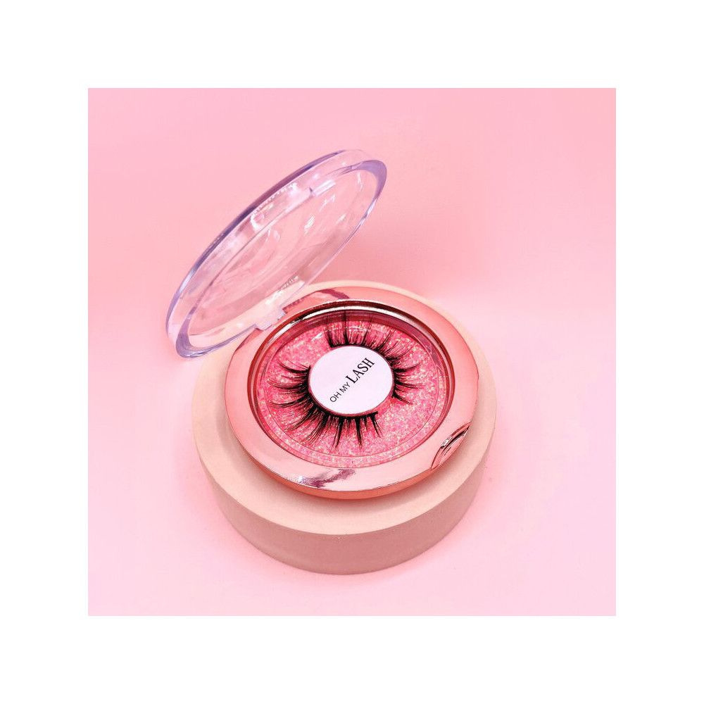 Faux cils dans un emballage rond. Boîte rose-doré avec couvercle transparent. Inscription: Oh My Lash.