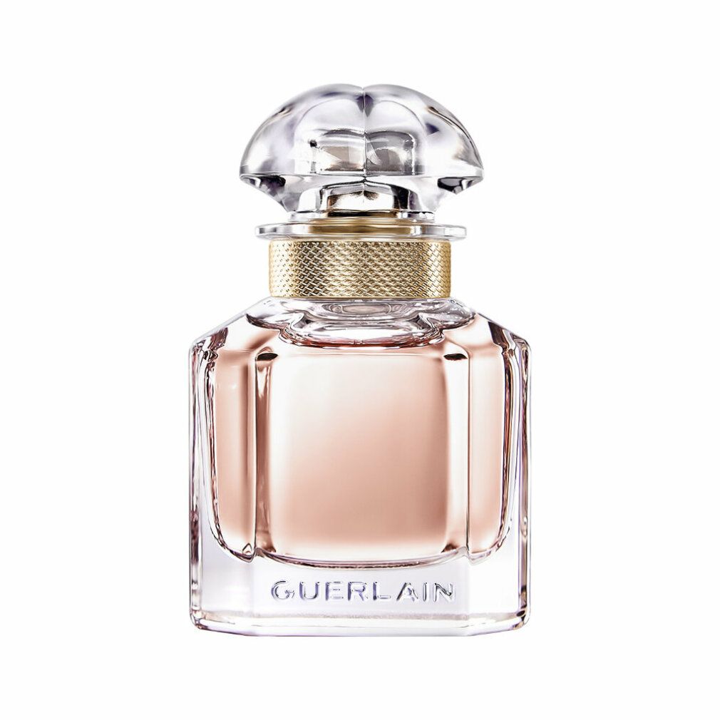 Flacon de parfum carré avec liquide rose, bouchon doré et couvercle transparent. Forme géométrique.