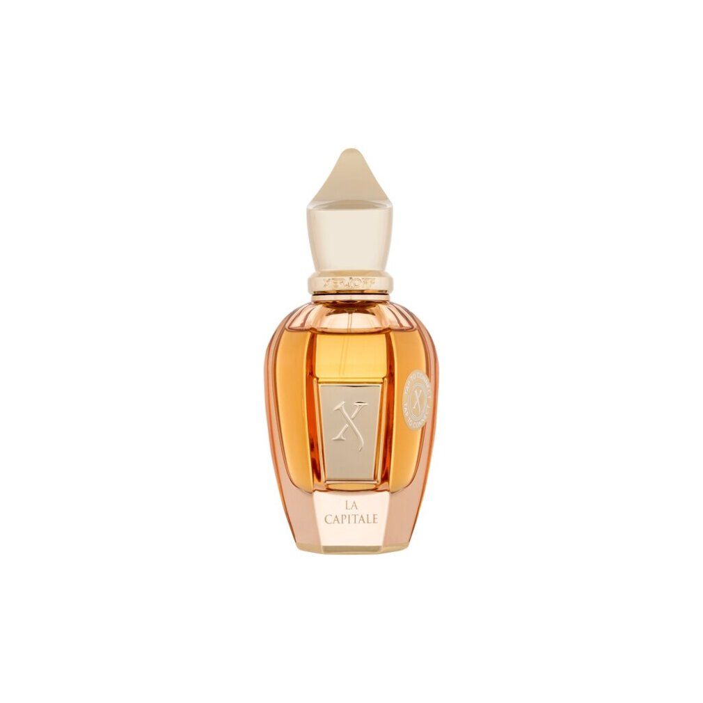 Une bouteille en verre dorée contenant un parfum ambré et un bouchon ivoire. L'étiquette indique 'LA CAPITALE'.