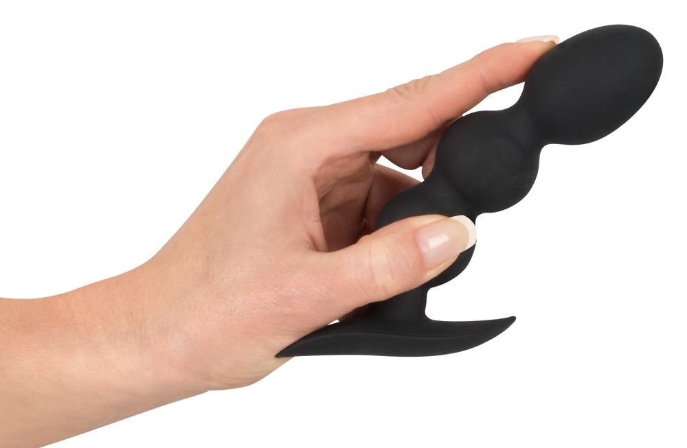 Hand die een zwarte anale plug met drie bollen en brede flens vasthoudt.