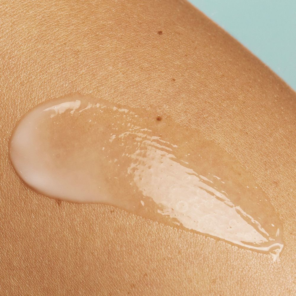 Gel transparent sur la peau. Texture claire. Sur peau claire. Fond bleu clair.