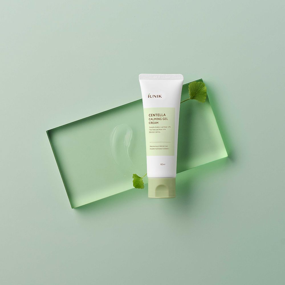 Tube blanche, bouchon vert. Inscription: iUNIK, Centella Calming Gel Cream, 60ml. Sur fond vert avec feuille.