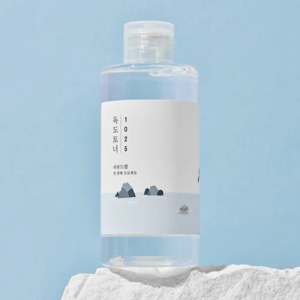 Transparante fles met wit etiket. Fles met witte dop. Blauwe achtergrond.