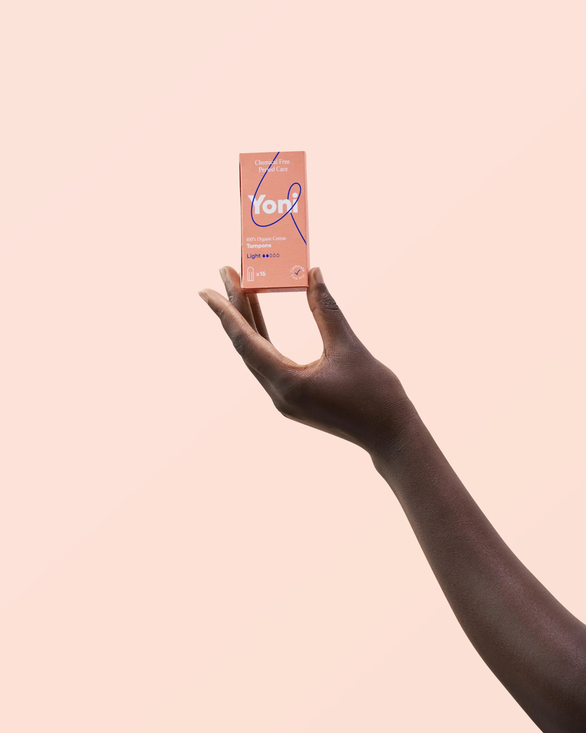 Een hand houdt een roze doos met het Yoni-logo. Op de doos staat "Light" en "Mini Tampons".