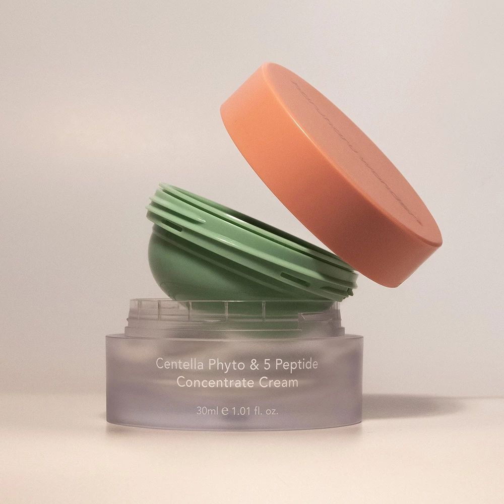 Pot de crème ouvert avec couvercle. Le pot et le couvercle sont de couleurs différentes.