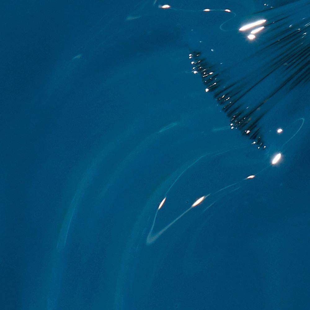 Vernis à ongles bleu brillant. Reflets sur la surface.