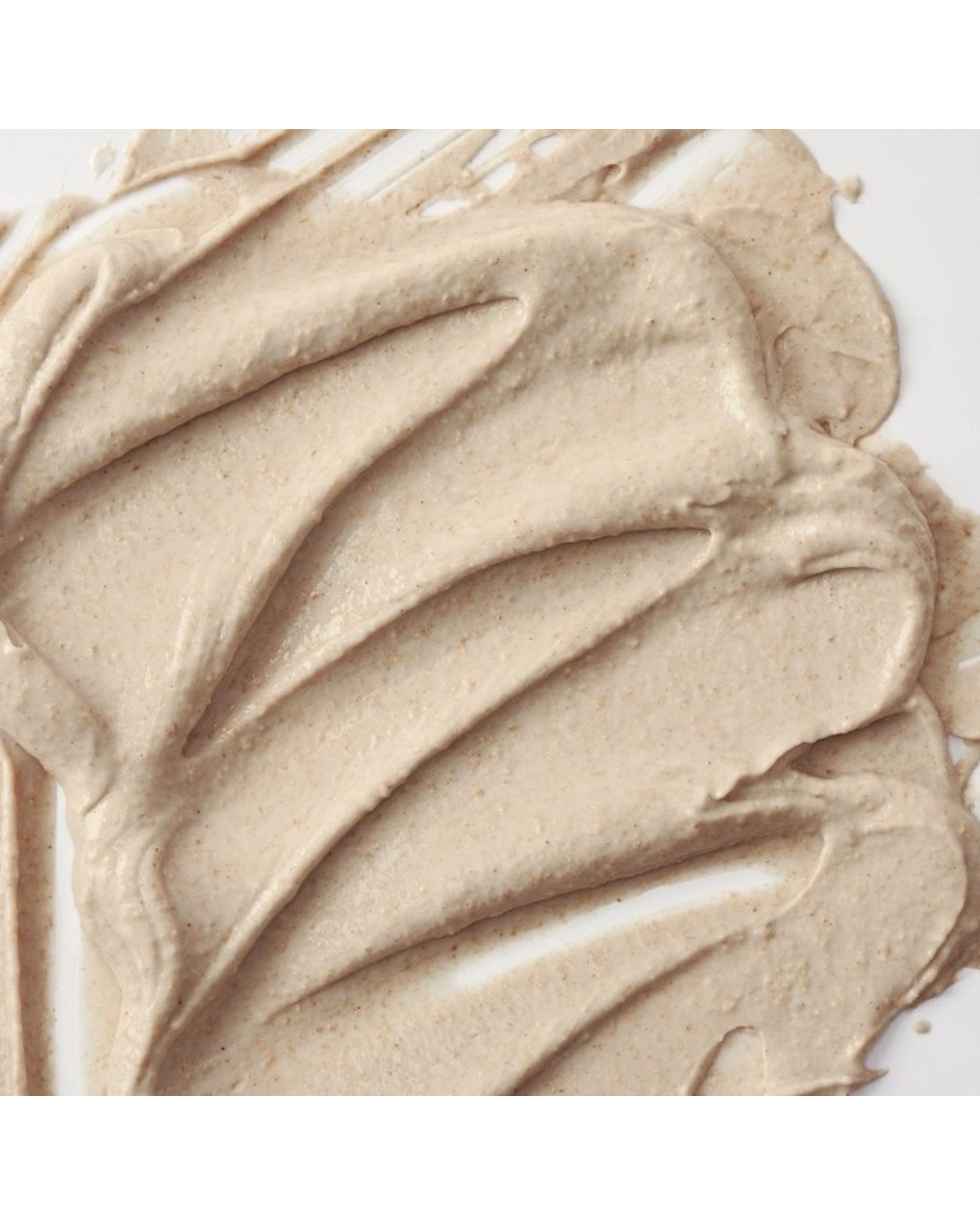 Gros plan sur un masque facial crémeux beige. La texture est visible.