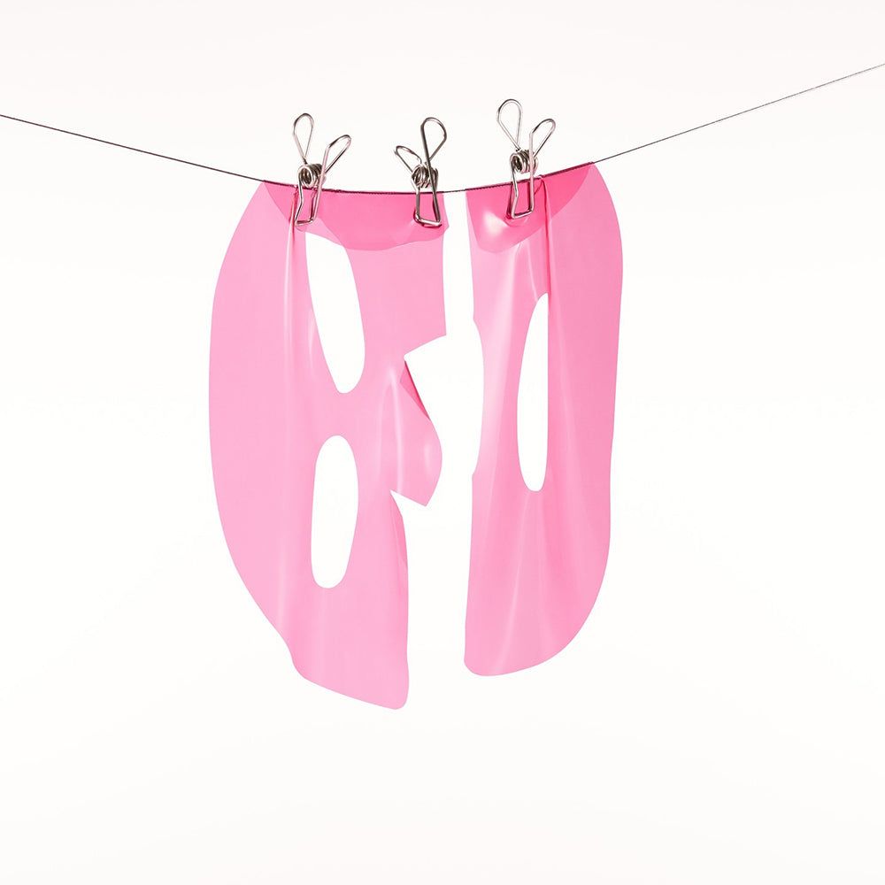Roze hydrogelmasker hangt aan een waslijn, vastgezet met knijpers.
