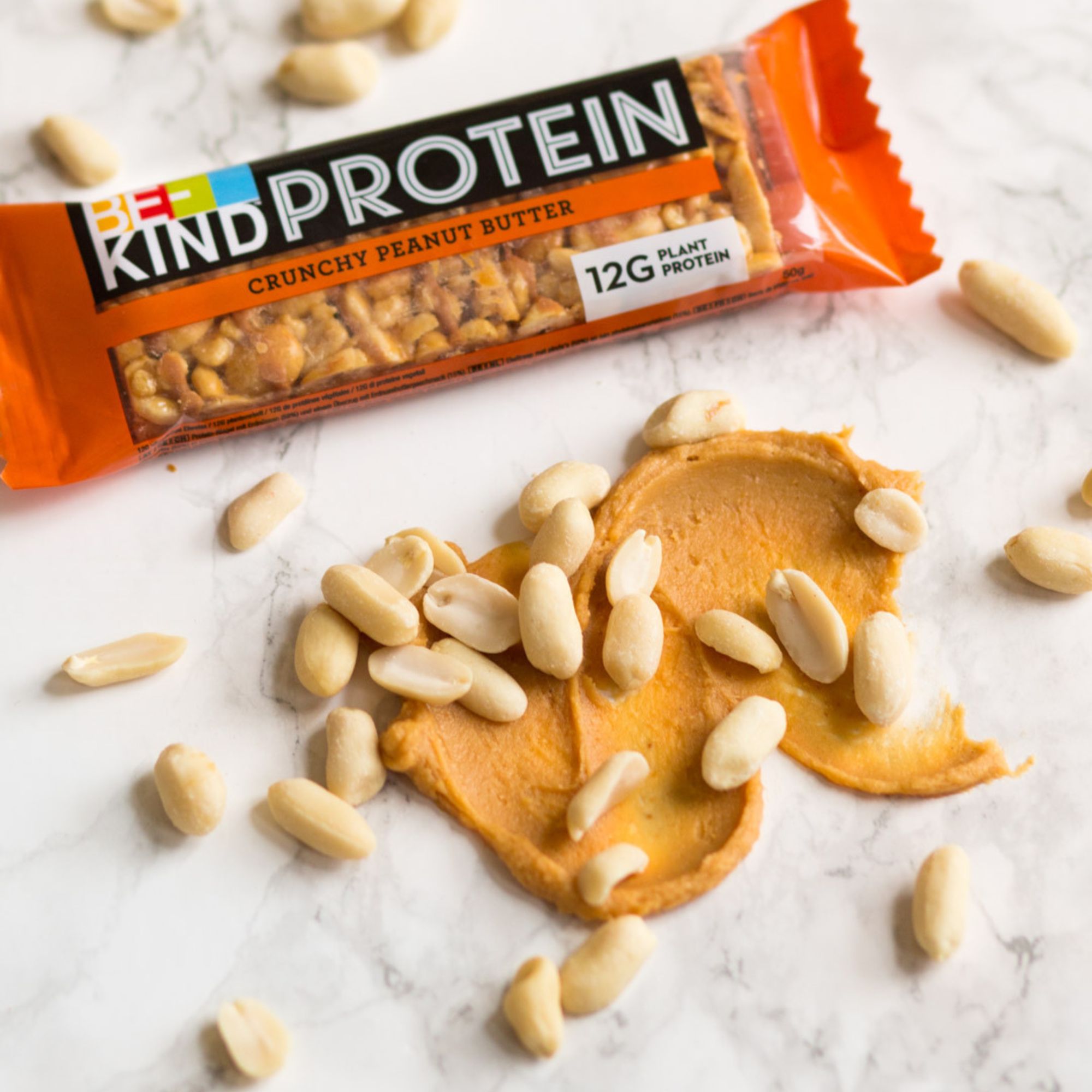 Verpakte reep met pinda's en pindakaas. Opschrift: Protein, Crunchy Peanut Butter, 12G Plant Protein.
