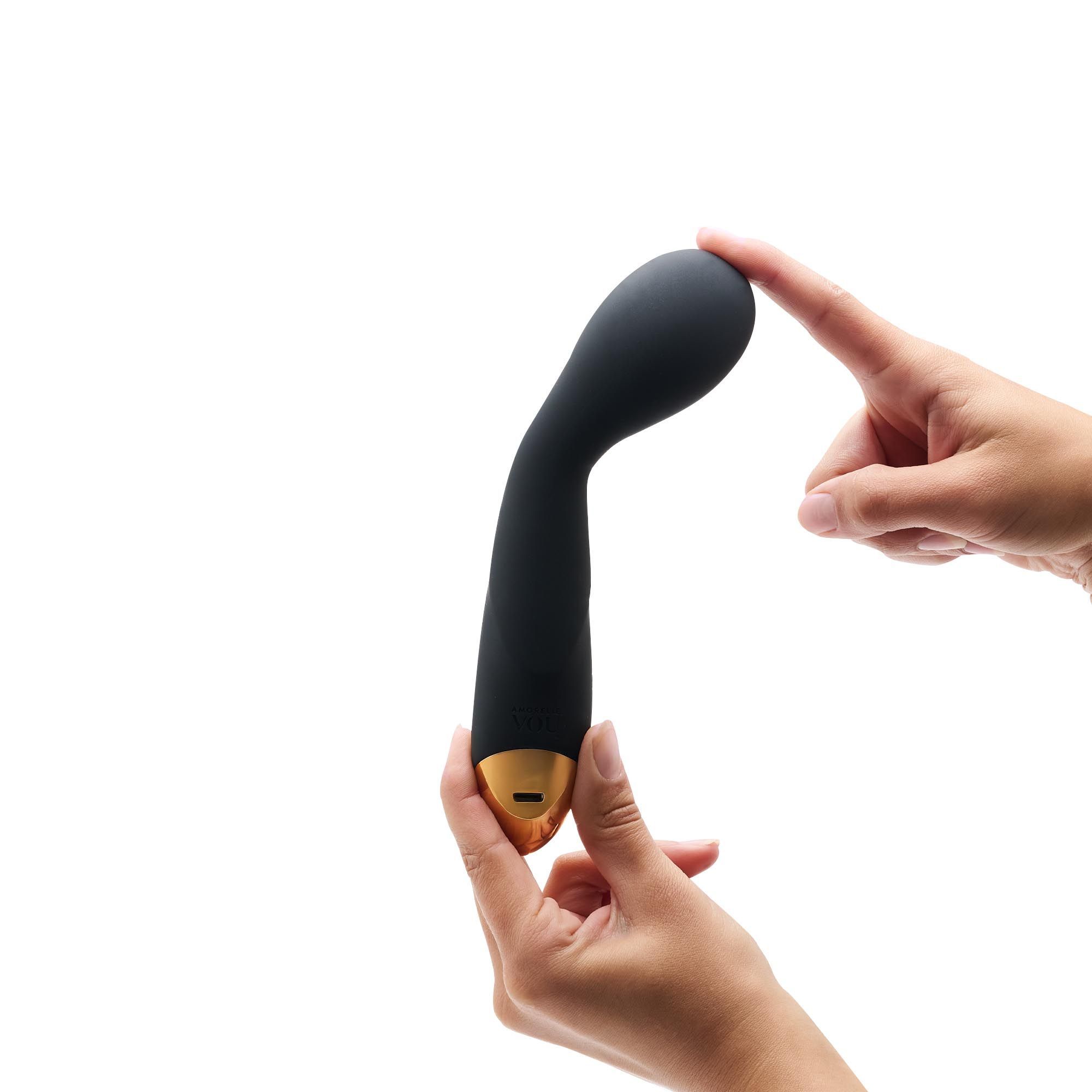 Donkerblauwe massage wand met gouden kop. Handen raken de wand aan. De wand heeft een langwerpige vorm.